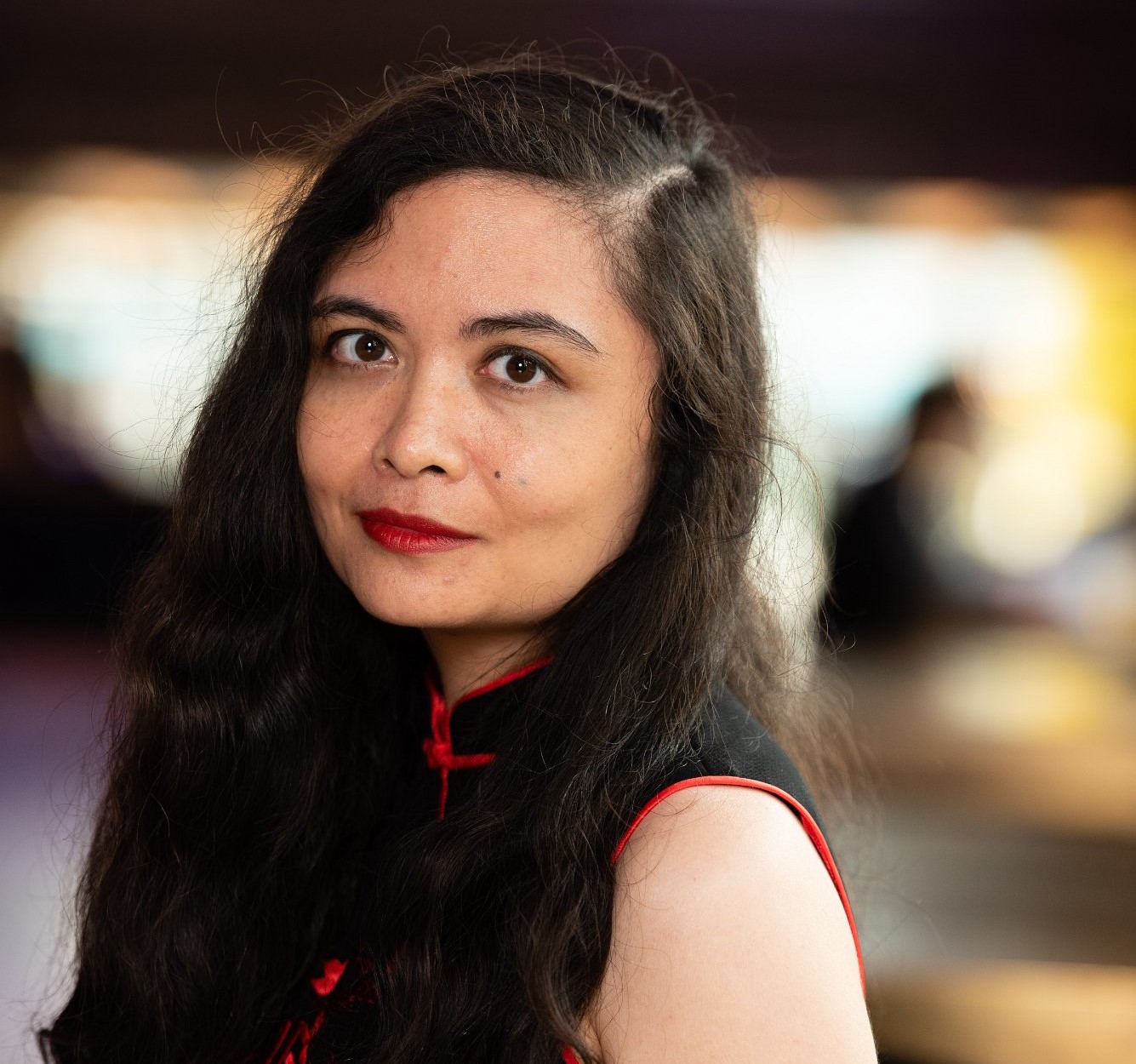 Head and shoulders headshot of a woman with long dark hair